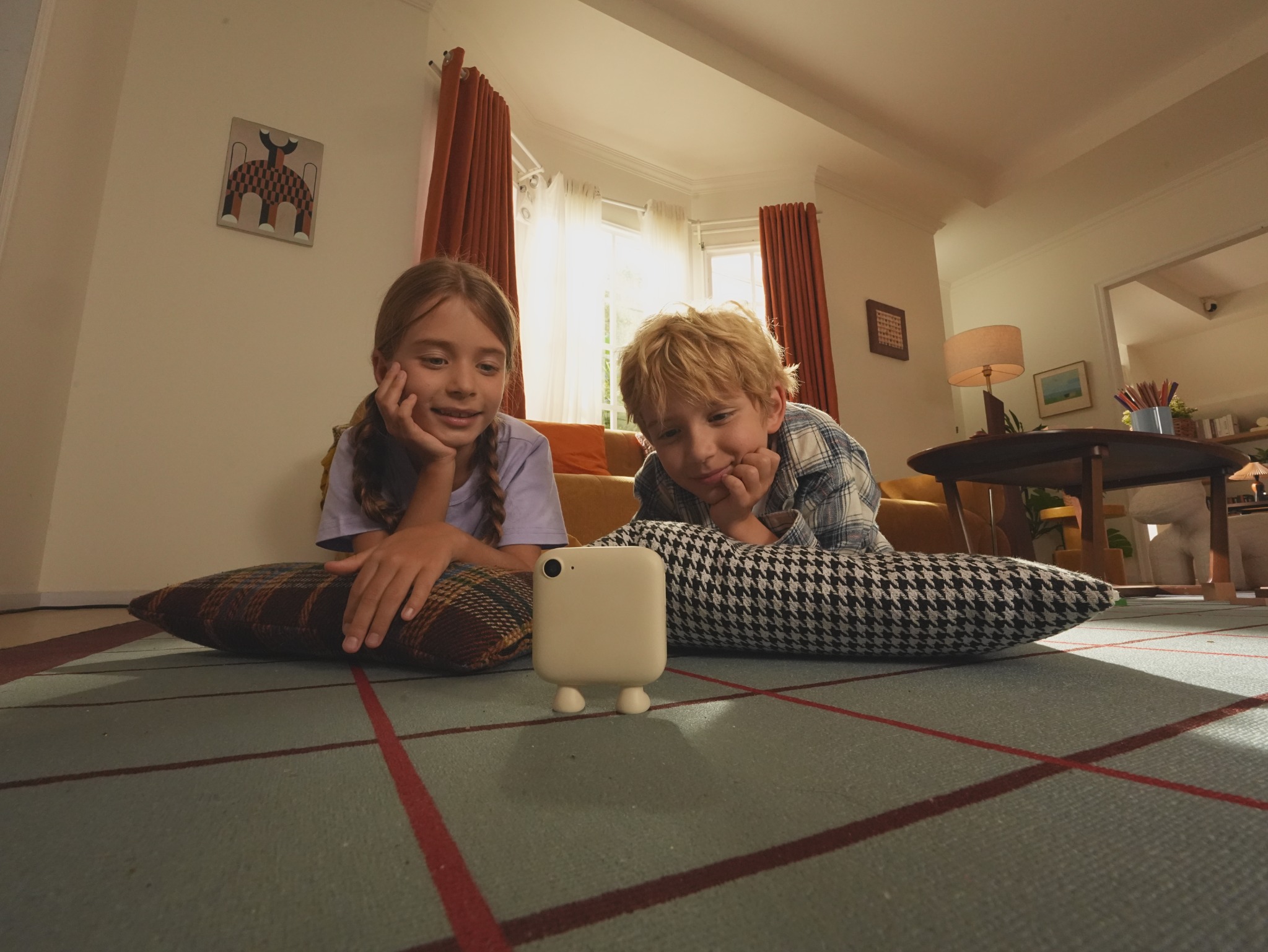 Two children lying on cushions and looking at Puddibear
